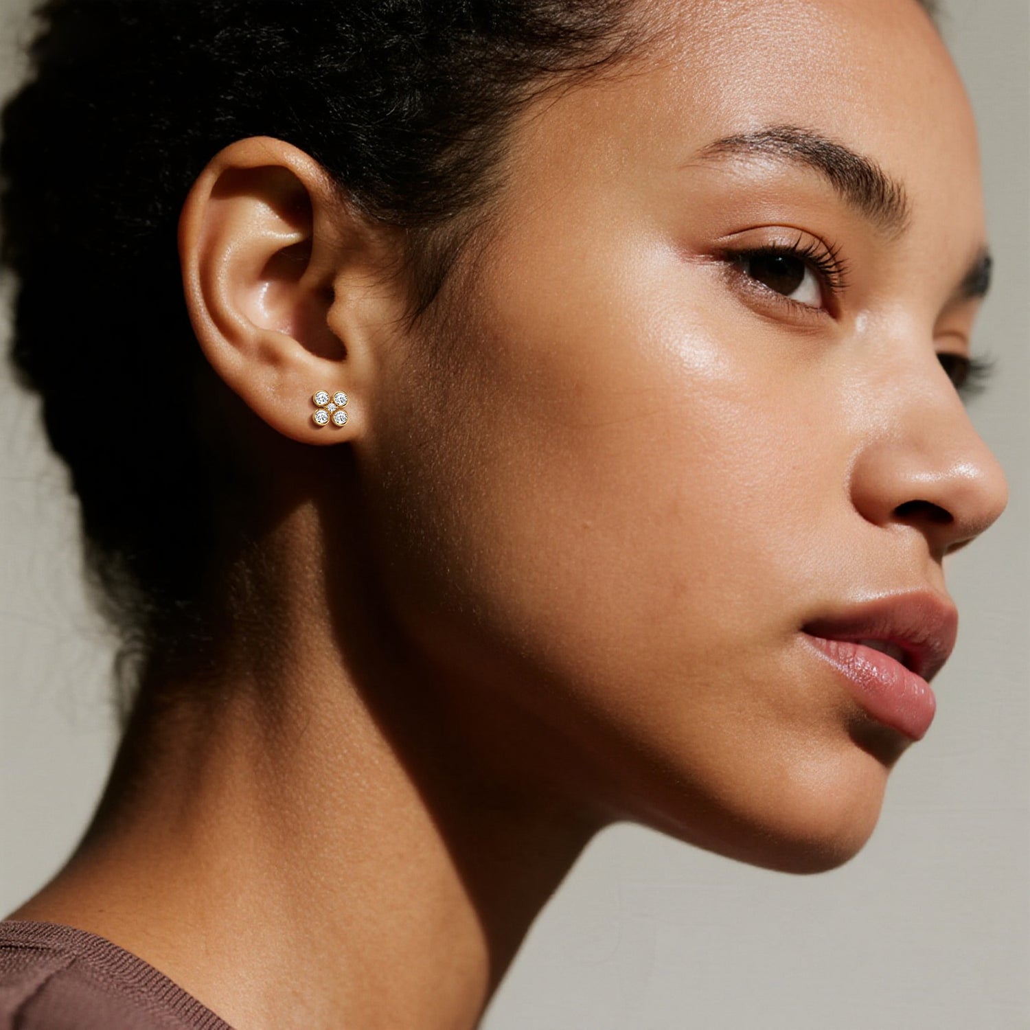 Close-up of a woman wearing earrings with a neutral background
