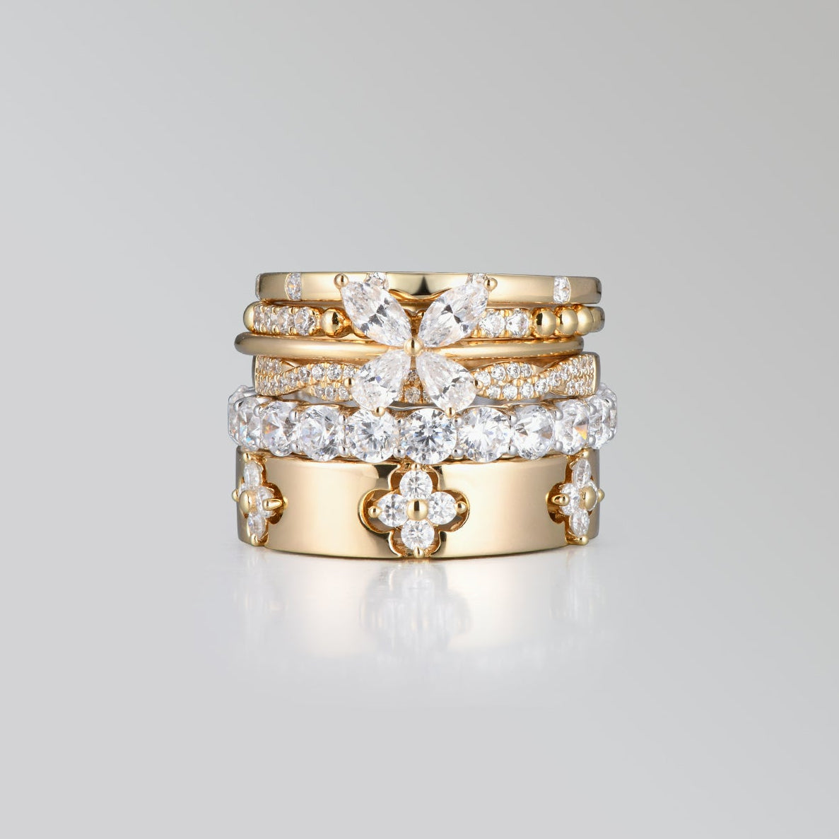 Set of gold rings with diamond accents on a light gray background