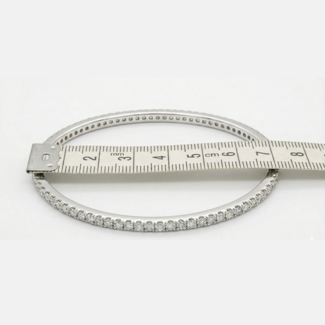 bangle with diamond accents and a ruler for size measurement on a white background